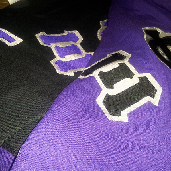 Black and purple Gamma Xi Phi t-shirts.